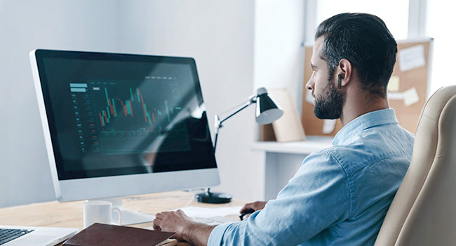 Wearing SW5 earbuds at a desktop workspace